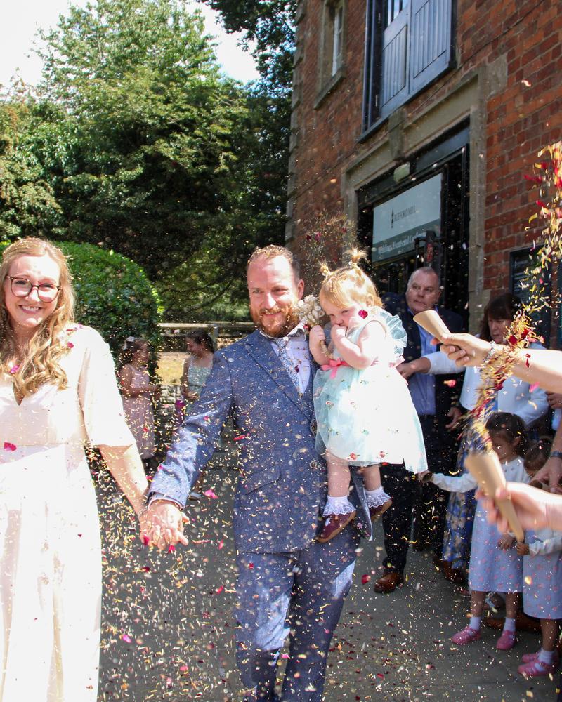 The couple walking through a confetti shower