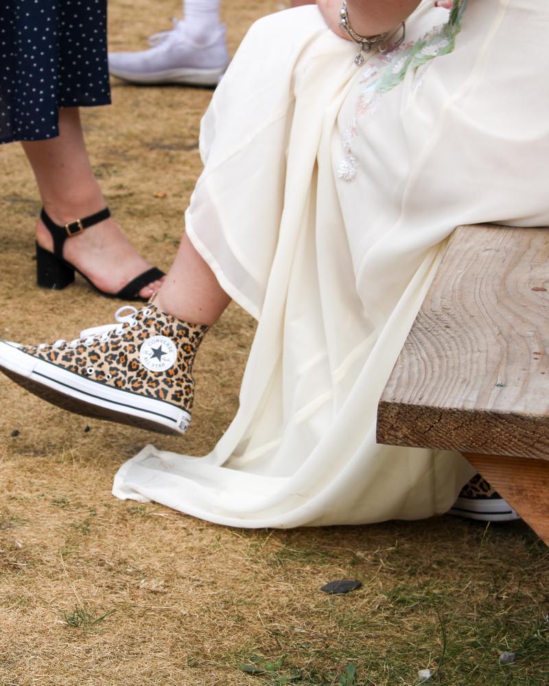 Leopard-print Converse peeking out from the wedding dress